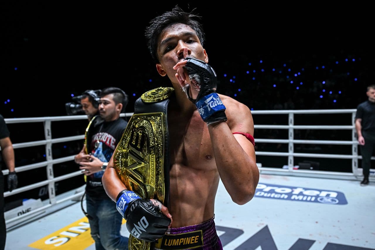 Founder of KIB GYM holding a championship belt in the ring